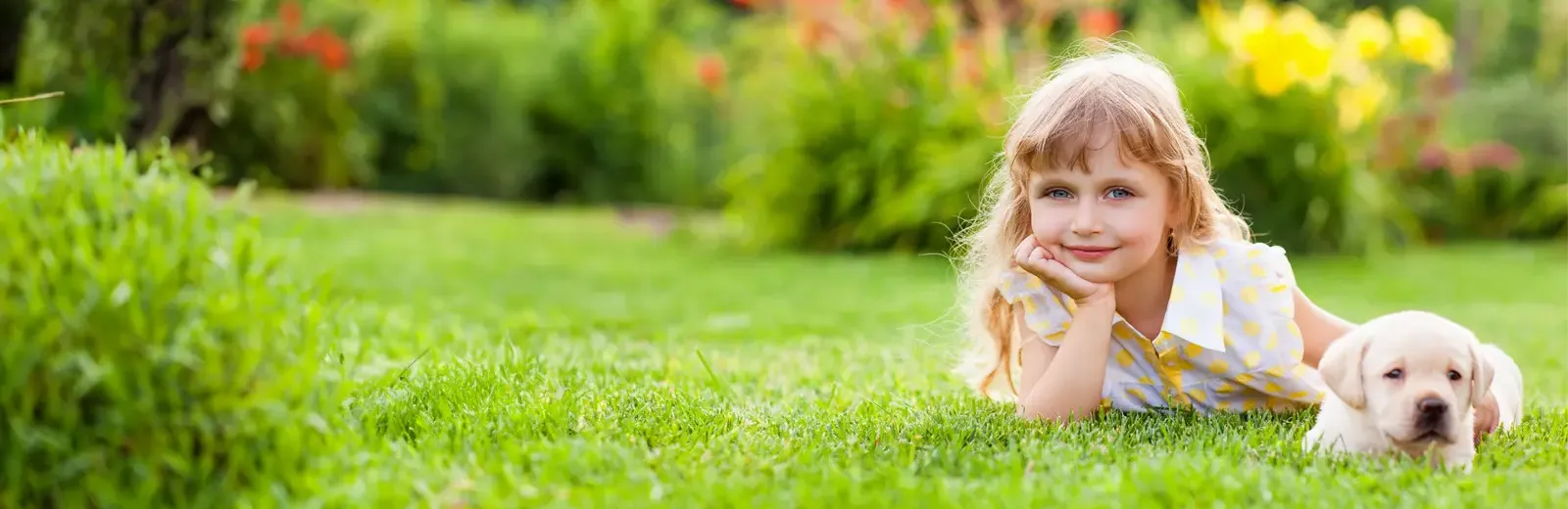 girl laying in grass with dog